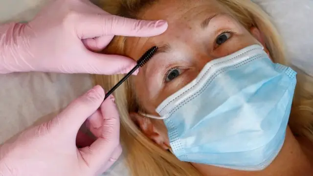 General view of woman having eyebrows done in a salon