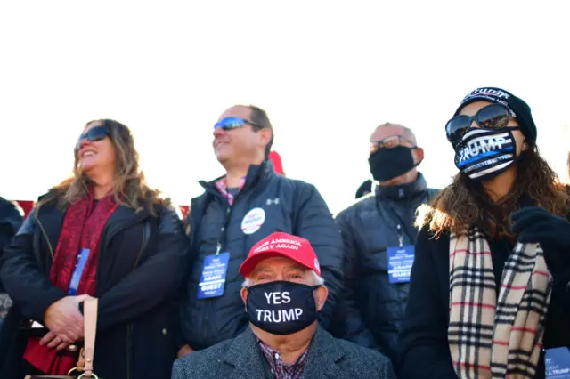 A man wears a "YES TRUMP" face mask due to the coronavirus pandemic before President Donald Trump arrives for a rally in Newtown, Pennsylvania