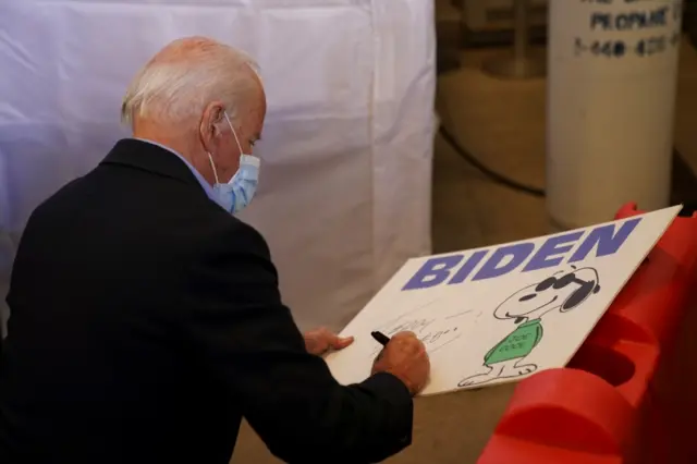 Joe Biden signs a banner at the event in Cleveland