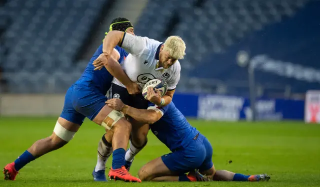 Oli Kebble is tackled by two France players