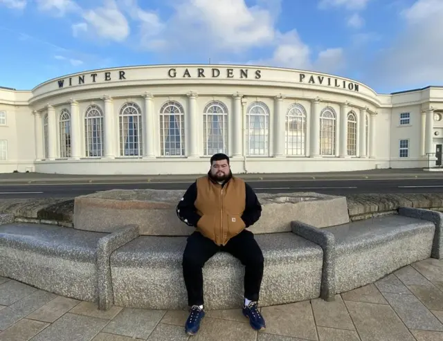 Samuel Wilmot sitting on a bench at Weston-super-Mare