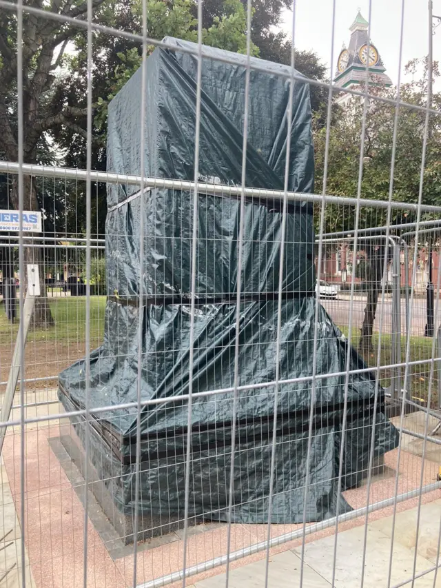 Metal fencing around wrapped up statue