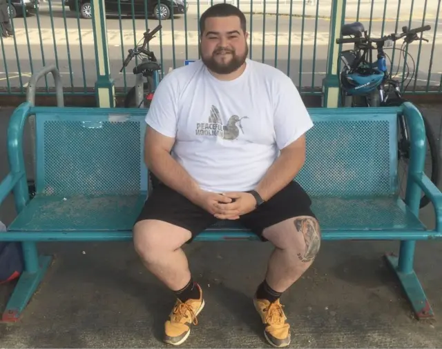 Samuel Wilmot sitting on a bench at Newport Station