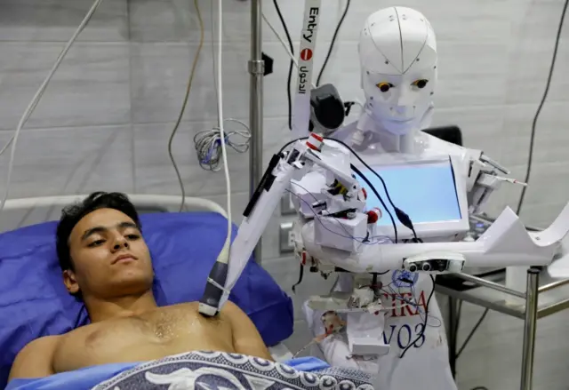 A volunteer is examined by Cira-03, a remote-controlled robot that runs tests on suspected coronavirus patients