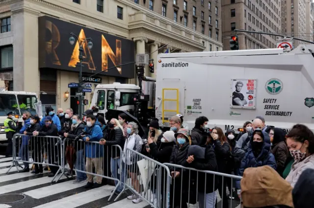 People look on from behind a fence during the 94th Macy's Thanksgiving Day Parade