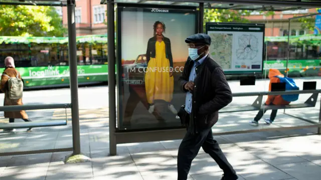 A man wearing a face mask as he walks through Nottingham city centre