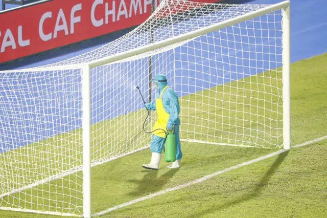 Health worker spraying the goal nets