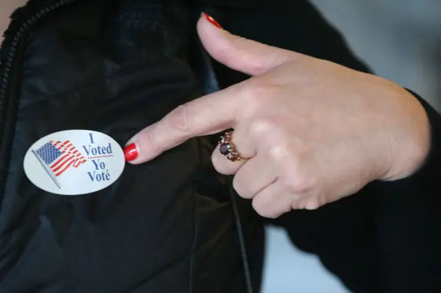 An 'I Voted' pin on a woman's jacket at a polling station at Union Market on Election Day