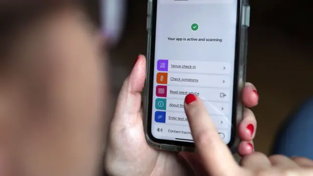 A person using the NHS app on their phone