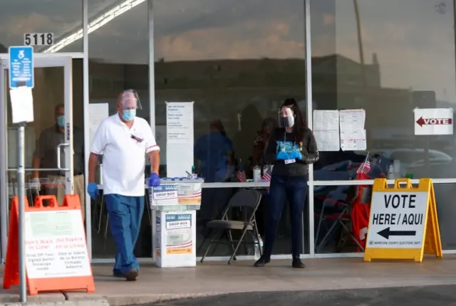 A man wearing a face shield and a protective mask leaves a polling station during the 2020 presidential election, in Phoenix, Arizona