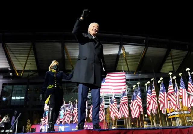 Joe Biden stands with his wife Jill Biden onstage during a drive-in campaign rally at Heinz Field in Pittsburgh