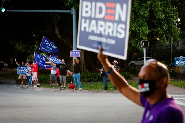 Supporters of US President Donald Trump and Democratic Presidential candidate and former US Vice President Joe Biden rally in front of a poll station at Coral Gable Branch Public Library in Miami, Florida on November 3, 2020