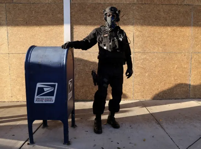 A police officer protected Kamala Harris happens to stand near a mailbox in Philadelphia