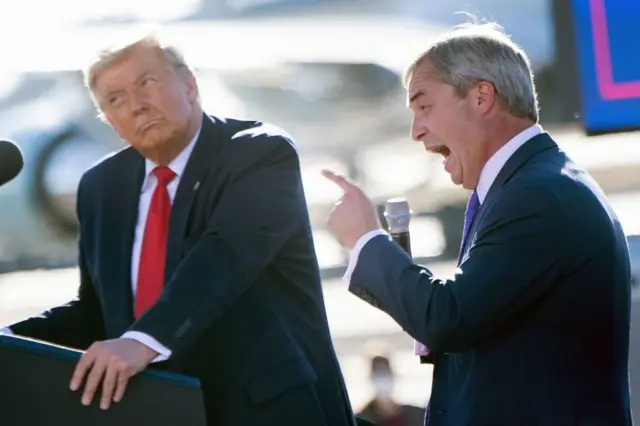 US President Donald Trump listens as Nigel Farage (R) speaks during a Make America Great Again rally at Phoenix Goodyear Airport October 28, 2020, in Goodyear, Arizona