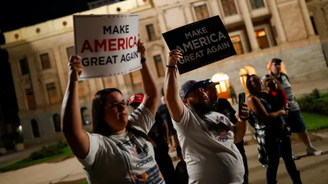 Supporters of U.S. President Donald Trump hold signs as they gather in front of the Arizona State Capitol Building to protest about the early results of the 2020 presidential election, in Phoenix, Arizona November 4, 2020.