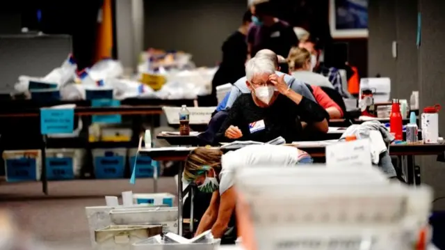 A poll worker gestures while processing absentee ballots at the Milwaukee Central Count the night of Election Day in Milwaukee, Wisconsin, November 3, 2020