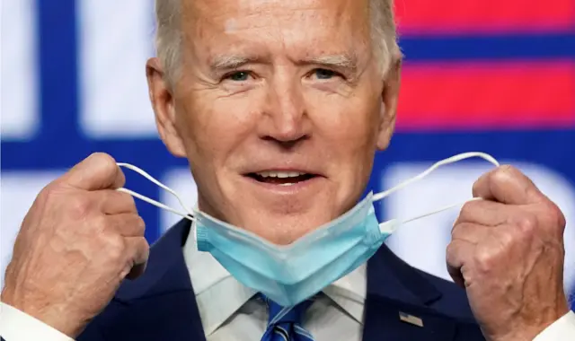 Democratic U.S. presidential nominee and former Vice President Joe Biden smiles as he pulls off his face mask to speak about the results of the 2020 U.S. presidential election during an appearance with in Wilmington, Delaware, 4 November, 2020.