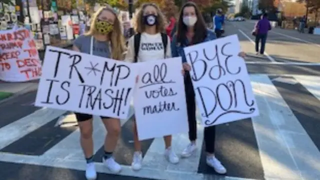 Women holding anti-Trump signs