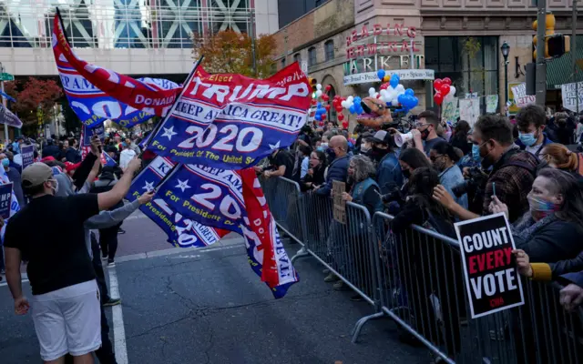 Trump and Biden supporters are in a tense standoff in Philadelphia, where postal votes are being counted