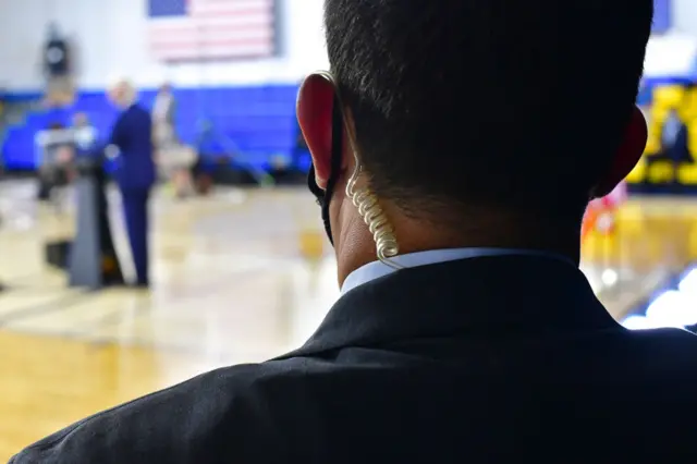 A Secret Service agent monitors activity as Joe Biden gives a speech in July