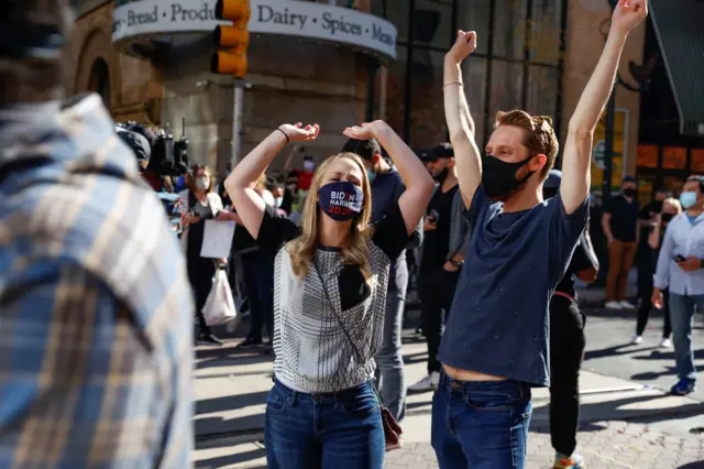 People react as media announce that Democratic US presidential nominee Joe Biden has won the 2020 U.S. presidential election, in, Philadelphia, Pennsylvania, U.S., November 7, 2020.