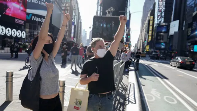 People react as media announce that Democratic U.S. presidential nominee Joe Biden has won the 2020 U.S. presidential election, on Times Square in New York City, 7 November, 2020.