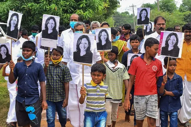 Residents hold placards with the portrait of Kamala Harris