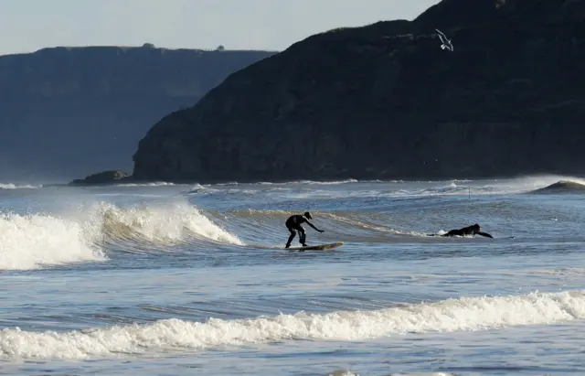 Surfers enjoy the winter sunshine in South Bay, Scarborough.