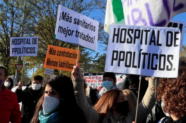 Paramedics hold banners reading "Hospital of Politicians" in Madrid