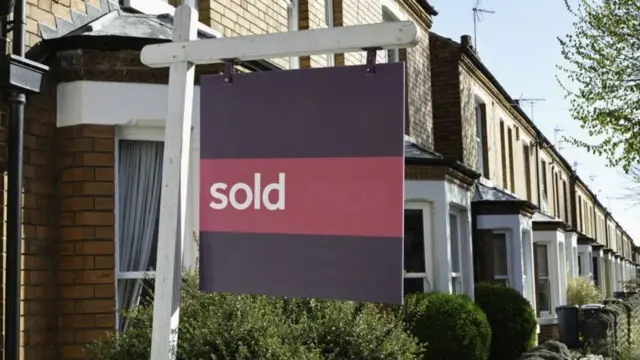 A house with a sold sign outside