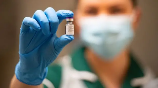 A nurse holds a phial of the Pfizer/BioNTech COVID-19 vaccine at University Hospital in Coventry