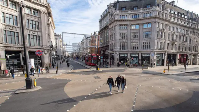 People walk along a quiet crossing at Oxford Circus in London