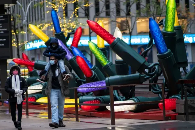 People in New York walk past Christmas decorations