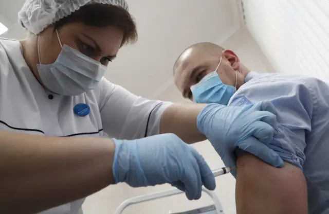 A Russian medic inoculates a man