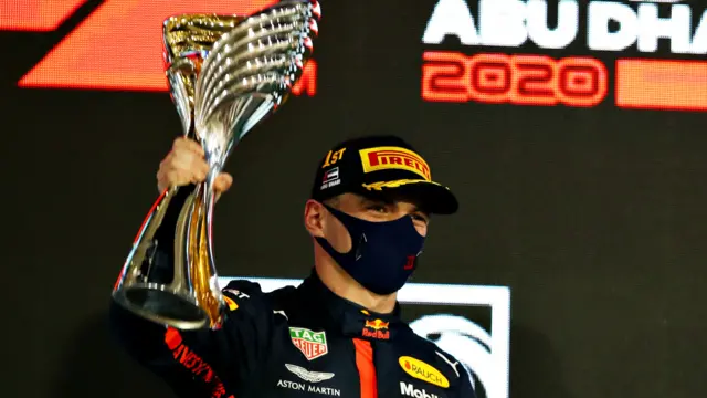 Max Verstappen holds aloft the winner's trophy