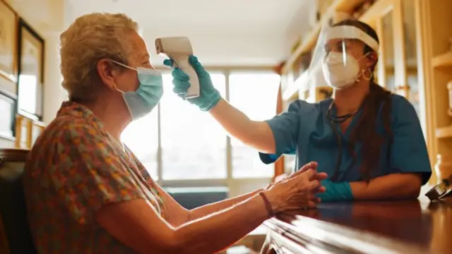 Woman having her temperature checked