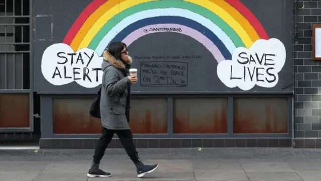 Woman walking by rainbow painting