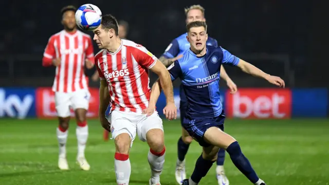 Stoke City striker Sam Vokes heads the ball under pressure from Wycombe Wanderers defender Josh Knight