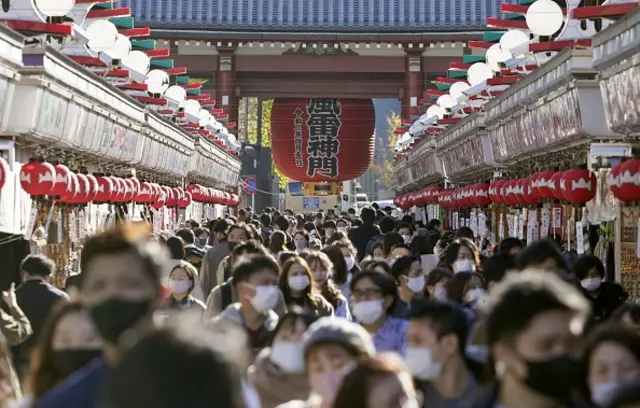 People wearing face masks walk in Tokyo's Asakusa area on Nov. 28, 2020. Japan reported the same day record daily coronavirus cases of over 2,600, with the number of seriously ill patients reaching 440, also a record