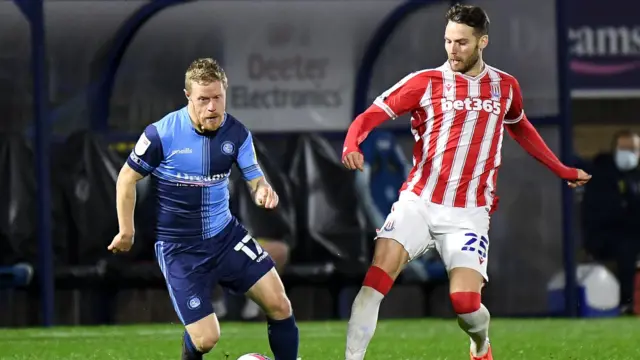 Wycombe Wanderers midfielder Daryl Horgan sprints forward with the ball under pressure from Stoke City midfielder Nick Powell