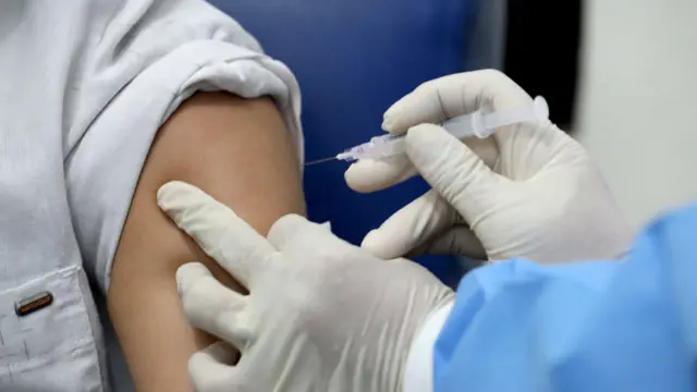 Doctor injects vaccine