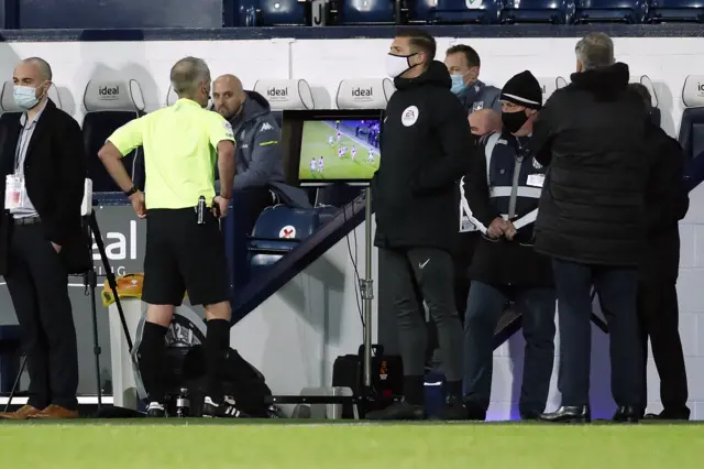 Referee Martin Atkinson looks at the VAR monitor bore sending off West Brom's Jake Livermore against Aston Villa