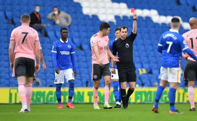 Referee Peter Bankes shows John Lundstram a red card