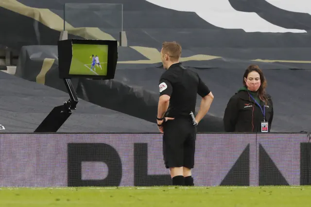 Craig Pawson looks at the VAR monitor before awarding a penalty to Leicester against Tottenham