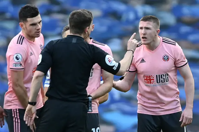 John Lundstram argues with Peter Bankes after being shown a red card