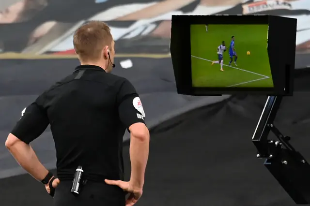 Craig Pawson looks at the VAR monitor before awarding a penalty to Leicester against Tottenham