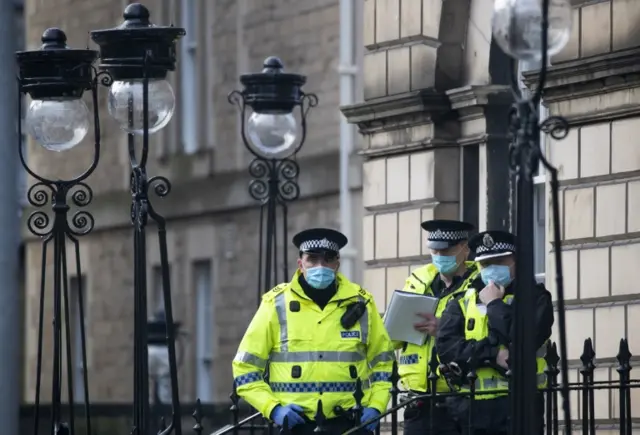 Police watch an anti-lockdown protest in Edinburgh in December 2020