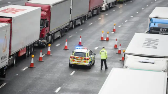 Police officers stop a lorry on the M20 motorway as part of operation stack in Maidstone, Kent, on December 21 after queues began to form in Dover harbour