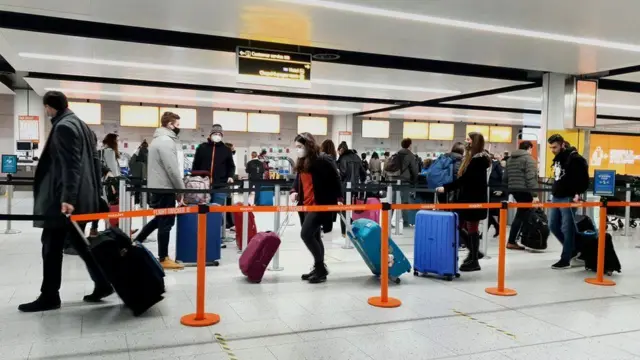 Passengers queue for check-in at Gatwick Airport in West Sussex