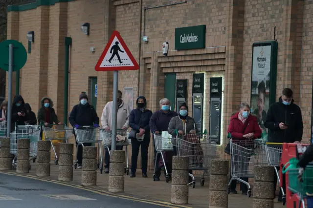 People queue outside a Morrisons supermarket in Whitley Bay